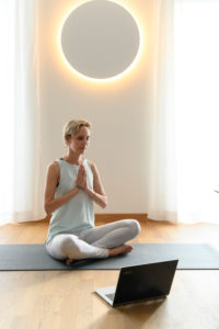 Woman 40+ practices yoga at home with notebook. Online yoga class. Woman 40+ practices yoga at home with notebook. Online yoga class.